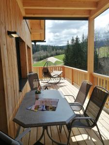 a patio with a table and chairs on a deck at Riesenbauer in Zeutschach
