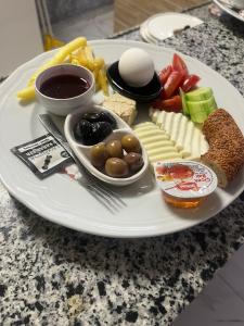 ein Teller mit Käse und anderen Lebensmitteln auf dem Tisch in der Unterkunft Ersoy İkiz Otel in Antalya