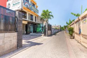 an empty street with buildings and palm trees at TwoSpaces Living at D'Rainbow Homestay in Mergoredjo