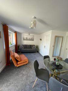 uma sala de estar com um sofá, uma mesa e cadeiras em Luxury One Bed Apartment Stevenage em Stevenage