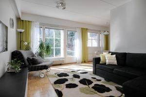 - un salon avec un canapé et une chaise dans l'établissement Apartments Karviaismäki, à Helsinki