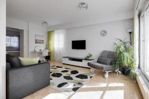 - un salon avec un canapé et une télévision dans l'établissement Apartments Karviaismäki, à Helsinki