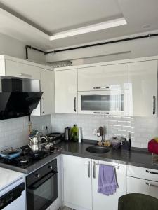 a kitchen with white cabinets and a stove top oven at Yeni Dairede Manzaralı Lüks Mobilyalı Ferah Daire in Sinop
