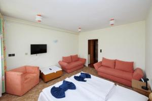 a living room with a bed and two chairs and a tv at Retro Lido - Vonyarcvashegy in Vonyarcvashegy
