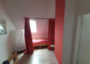 a room with a red bed and a window at Haus Seenplatte in Groß Nemerow