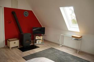 a living room with a red wall and a stove at Haus Seenplatte in Groß Nemerow