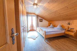 um quarto com uma cama num quarto de madeira em Ferienwohnung Berghof em Wallgau