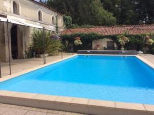 een groot blauw zwembad voor een gebouw bij Chateau Guest House in Villetoureix