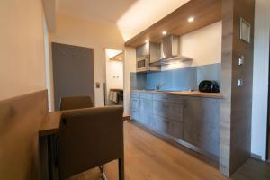 uma cozinha com armários de madeira e uma bancada em Das Reinisch Just Rooms em Schwechat