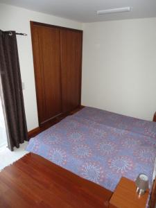 a bedroom with a bed and a wooden door at Lena's Home in Ponta Delgada