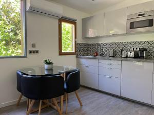 a kitchen with a table and chairs in a kitchen at Studio Luxe + jardin et terrasse in Pontoise