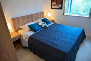 um quarto com uma cama com lençóis azuis e uma janela em Apartment Leo Blue em Vela Luka