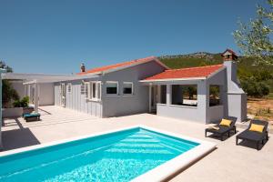 a villa with a swimming pool and a house at House Potirna in Blato