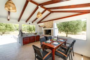 uma cozinha e sala de jantar com uma mesa de madeira e cadeiras em House Potirna em Blato