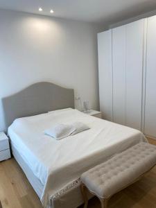 Schlafzimmer mit einem großen weißen Bett und einer Bank in der Unterkunft Cairoli in Riccione