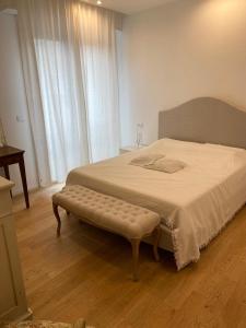 Schlafzimmer mit einem Bett mit einer Bank in der Unterkunft Cairoli in Riccione