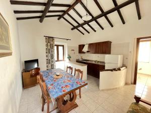 ヴィッラシミーウスにあるAppartamento Nassia 1 By La Via Del Mare Viaggi e Vacanzeのテーブルと椅子のあるキッチンとダイニングルーム