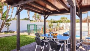eine Terrasse mit Tisch und Stühlen auf einem Deck in der Unterkunft Chalet El Cancelín Conil de la Frontera by Ruralidays in Conil de la Frontera