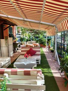 een patio met banken en een tafel onder een pergola bij Rooms and Breakfast da Carla in Sestri Levante