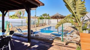 eine Terrasse mit Stühlen und einem Swimmingpool in der Unterkunft Chalet El Cancelín Conil de la Frontera by Ruralidays in Conil de la Frontera