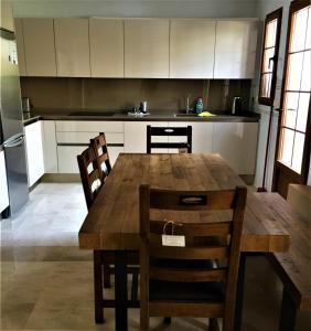 eine Küche mit einem Esstisch aus Holz und Stühlen in der Unterkunft La Manga Club Townhouse in Cartagena
