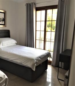 a bedroom with a bed and a large window at La Manga Club Townhouse in Cartagena