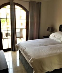 1 dormitorio con cama y ventana grande en La Manga Club Townhouse en Cartagena