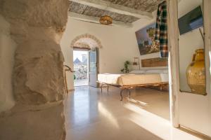 a bedroom with a bed and a stone wall at Trulli Holiday Deluxe & Wellness in Alberobello