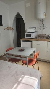 uma cozinha com uma mesa e cadeiras numa cozinha em CASA MORENA MiA APARTAMENTOS em Granada