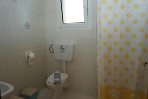 a small bathroom with a toilet and a window at Manos in Megás Limniónas +28 photos