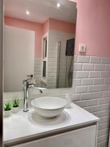 a bathroom with a white sink and a mirror at Xuloss Apartments 2 in Loyola