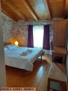 Schlafzimmer mit einem Bett und einem Fenster mit lila Vorhängen in der Unterkunft Villa Barbara - Orihi in Barban