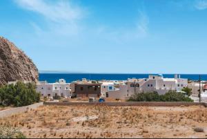 Spiridoula Villa - Santorini Seaside Retreats في بيريسا: إطلالة على مدينة في خلفية المحيط