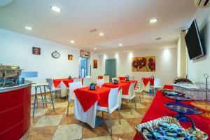 a restaurant with red tables and white chairs at San Martino Apartment Sofia in Cassibile