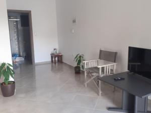 sala de estar con mesa, silla y escritorio en Vagelis Nemea apartments, en Neméa