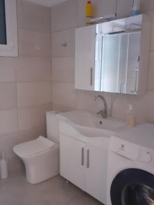 bagno bianco con lavandino e servizi igienici di Vagelis Nemea apartments a Neméa