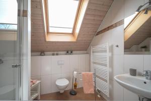 a bathroom with a toilet and a sink and a window at Ferienhaus Hafenresidenz in Greetsiel +11 photos
