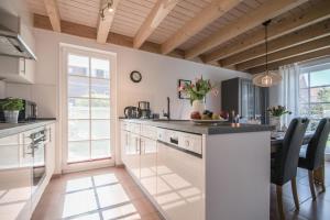 a kitchen with a white island with a counter top at Ferienhaus Hafenresidenz in Greetsiel