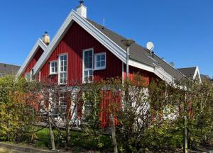 a red house with a black roof at Ferienhaus Hafenresidenz in Greetsiel