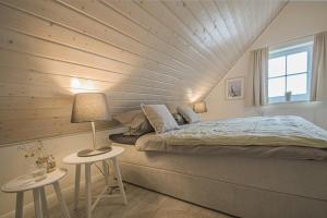 een slaapkamer met een groot bed en 2 tafels bij Hafenparadies in Greetsiel