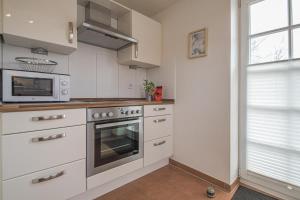 een keuken met een fornuis en een magnetron bij Hafenparadies in Greetsiel +14 foto's