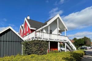 een groot rood-wit huis met een balkon bij Hafenparadies in Greetsiel