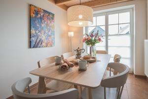 een eetkamer met een houten tafel en stoelen bij Hafenparadies in Greetsiel