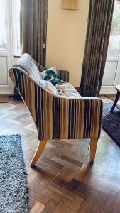 a striped couch in a living room with a window at Vincent House London Residence in London