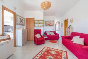 sala de estar con 2 sofás rojos y cocina en Villa Emerald, en Reitani