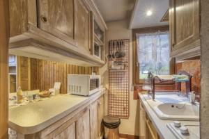 eine Küche mit einer Spüle und einer Mikrowelle in der Unterkunft Studio cabine Le Charvet in Le Grand-Bornand