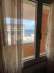 a window with a view of the ocean at Dimora Pina sul mare in Codaruina