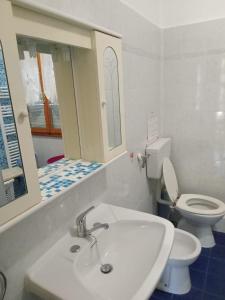 a bathroom with a white sink and a toilet at Casa Dirindo in Carrodano Inferiore