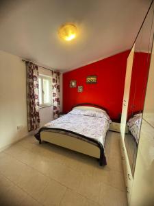 Un dormitorio con una cama con una pared roja. en Dimora Pina sul mare, en Codaruina