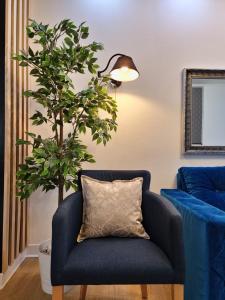 uma cadeira azul com uma almofada ao lado de uma planta em Apartment Roosevelt em Belgrado